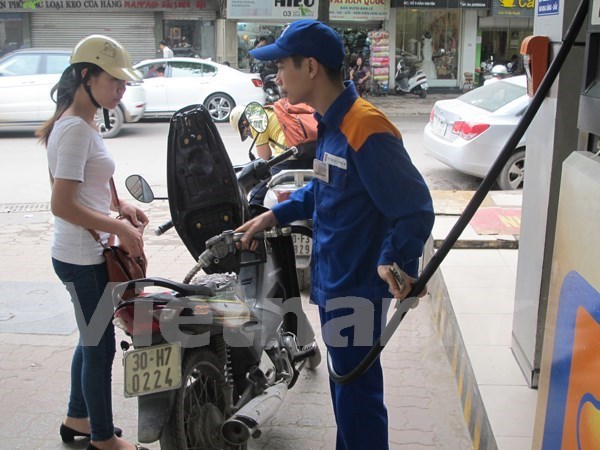 Nhân viên Petrolimex đang bán xăng cho khách hàng (Ảnh: Vietnam+)