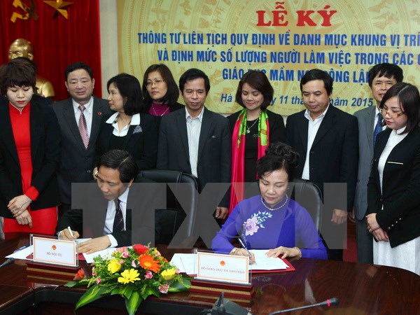 Thứ trưởng Bộ Giáo dục và Đào tạo Nguyễn Thị Nghĩa (phải) ký Thông tư liên tịch với Thứ trưởng Bộ Nội vụ Trần Anh Tuấn tại buổi lễ. (Ảnh: TTXVN)