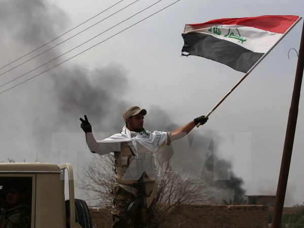 Lực lượng bán quân sự Iraq ăn mừng chiến thắng sau khi giành lại quyền kiểm soát làng Albu Ajil ngày 9/3. (Nguồn: AFP/TTXVN)