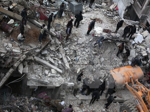 Tìm kiếm nạn nhân bị mắc kẹt trong đống đổ nát sau các cuộc không kích tại Douma, phía Đông thủ đô Damascus hôm 9/2/2015. (Nguồn: AFP/TTXVN)