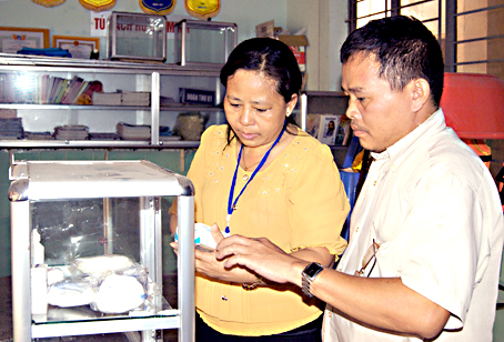 Bà Võ Thị Bình kiểm tra tủ thuốc mà mô hình trang bị để sơ cứu ban đầu cho nạn nhân tại ấp 5, xã An Phước. Ảnh: C.TÚ