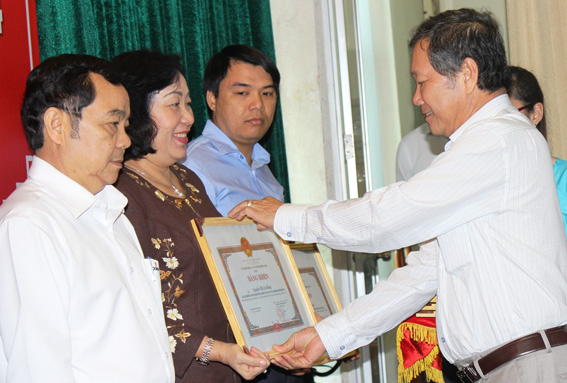 Phó chủ tịch UBND tỉnh Trần Minh Phúc trao bằng khen cho lãnh đạo các doanh nghiệp nhà nước hoạt động hiệu quả. Ảnh: B.Nguyên       