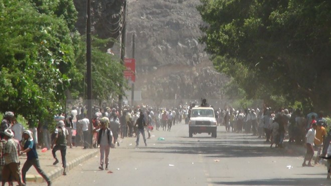 Người dân Yemen chạy khỏi khu vực xung đột gần sân bay Aden. (Nguồn: AFP/TTXVN)