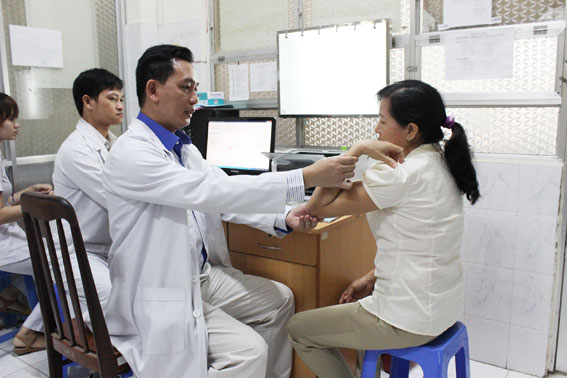 Bác sĩ CKII Nguyễn Trọng Anh đang khám bệnh về khớp vai cho một bệnh nhân.