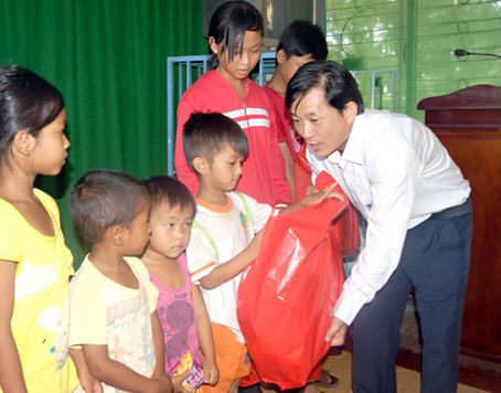 Ông Hoàng Văn Long, Quyền Giám đốc Quỹ Bảo trợ trẻ em tỉnh, tặng quà cho trẻ em có hoàn cảnh khó khăn tại xã Sông Nhạn (huyện Cẩm Mỹ). Ảnh: N.Sơn