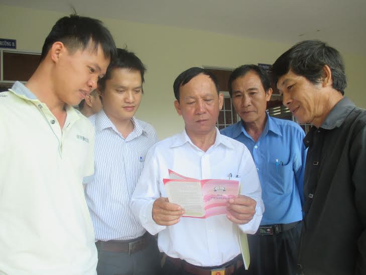 Ông Nguyễn Minh, Phó giám đốc Trung tâm TGPLNN tỉnh (người đứng giữa cầm tờ rơi) giải đáp thắc mắc của các đại biểu