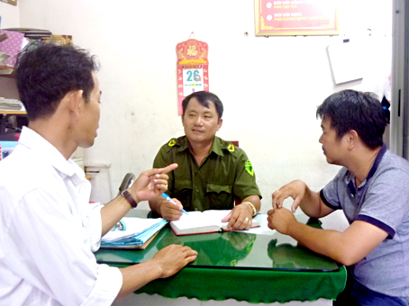 Các anh: Lê Khâm Toàn (trái) và Ứng Thế Khìn báo cáo cho Công an xã Phước Thái (huyện Long Thành) vụ bắt 2 tên cướp xe máy trên địa bàn xã.