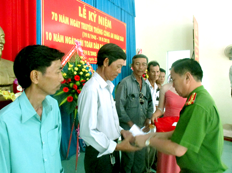 Đại diện Công an huyện Nhơn Trạch  tặng quà cho người dân nghèo trong đợt phát động phong trào Toàn dân bảo vệ an ninh Tổ quốc kết hợp với công tác dân vận ở xã Phú Hữu, Nhơn Trạch.