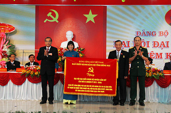 Đồng chí Trần Văn Tư và đồng chí Nguyễn Văn Nam trao bức trướng cho Đảng bộ huyện Cẩm Mỹ.