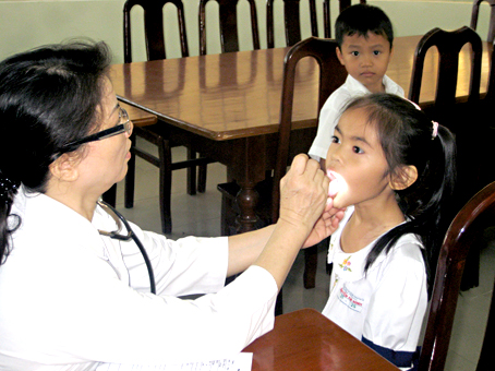 Học sinh, sinh viên là đối tượng bắt buộc tham gia bảo hiểm y tế.  Trong ảnh: Bác sĩ chăm sóc răng miệng cho học sinh Trường tiểu học Nguyễn An Ninh (TP.Biên Hòa).