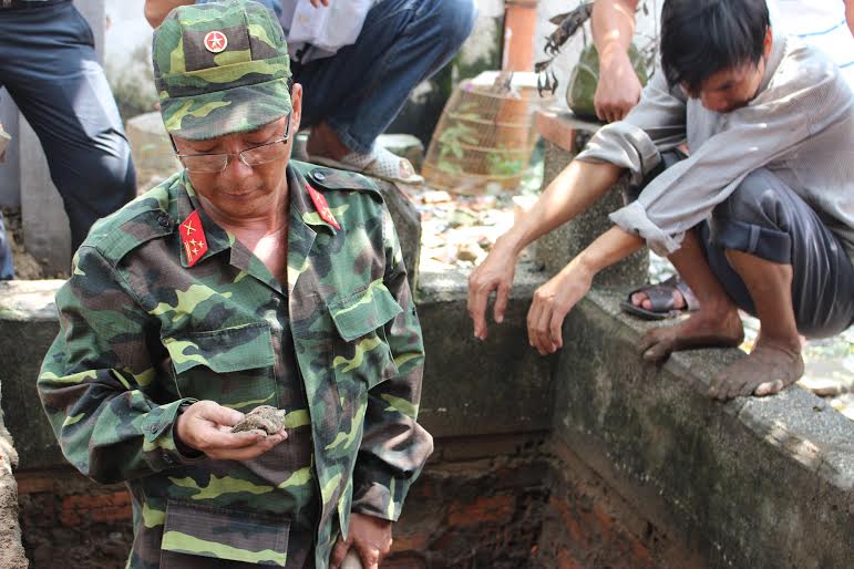Trưởng ban Chính sách, Bộ chỉ huy Quân sự tỉnh thượng tá Đoàn Công Tâm đang xem một mảnh xương vừa tìm thấy.