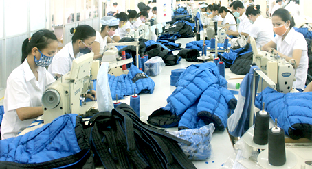 Cộng đồng kinh tế ASEAN chính thức thành lập sẽ tăng lợi thế cho các công ty may mặc. Trong ảnh: Sản xuất tại Công ty cổ phần Tổng công ty may Đồng Nai.