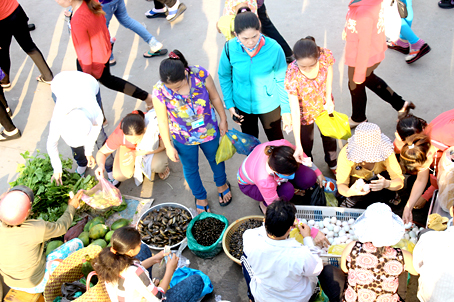 Sau giờ tan ca, công nhân Công ty Pouchen Việt Nam ở xã Hóa An,TP.Biên Hòa đi chợ bên lề đường.                                                                          Ảnh: N.LIÊN