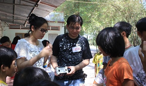 Gabriel Kang (C) shows children how to fly a drone at the Thien Binh orphanage in Dong Nai Province on December 6, 2015.