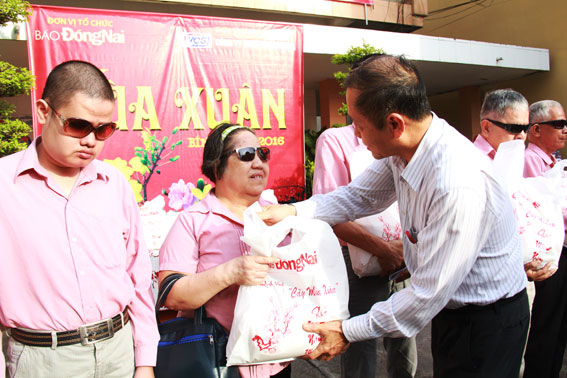 Ông Trần Huy Thanh, Tổng biên tập Báo Đồng Nai (trái) trao quà cho các thành viên Chi hội người mù TP.Biên Hòa