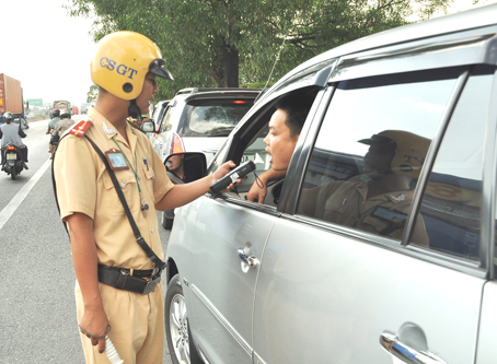 Lực lượng Cảnh sát giao thông Công an tỉnh kiểm tra nồng độ cồn của lái xe di chuyển trên đường.