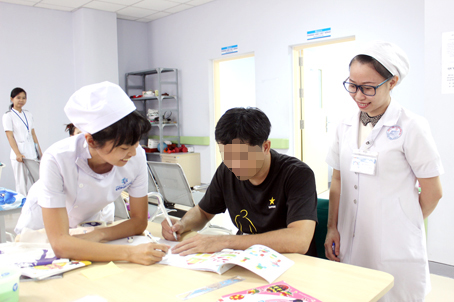 Các kỹ thuật viên người Nhật và Việt Nam cùng hướng dẫn bệnh nhân làm bài tập tìm hình. Ảnh: An An