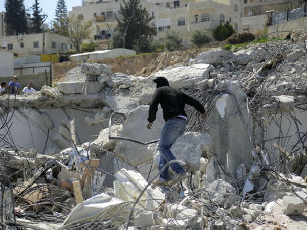 Người dân Palestine đang tìm kiếm vật dụng ở những ngôi nhà bị phá hủy. (Nguồn: Reuters)