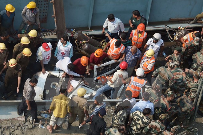 Lực lượng cứu hộ làm nhiệm vụ tại hiện trường vụ sập cầu vượt. (Nguồn: AFP/TTXVN)