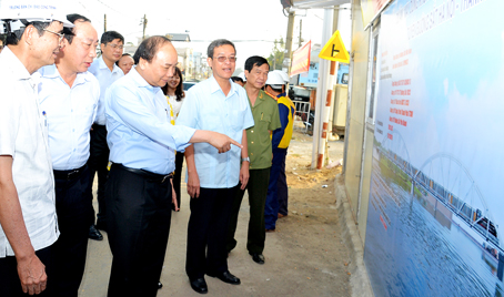 Phó thủ tướng Nguyễn Xuân Phúc (giữa) cùng Chủ tịch UBND tỉnh Đinh Quốc Thái (áo trắng bên phải) xem phối cảnh cầu Ghềnh mới. Ảnh: K.Giới