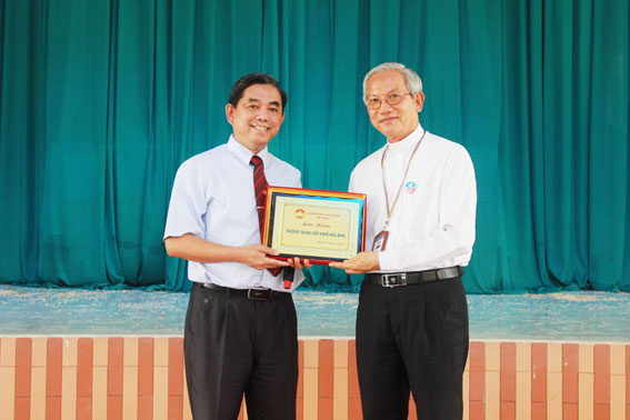 Đồng chí Huỳnh Văn Tới, Ủy viên Ban TVTU, Chủ tịch UBMTTQ tỉnh tặng quà lưu niệm cho nhà trường