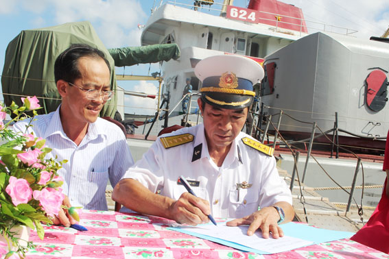 Đại tá Lê Đình Việt, Tổ trưởng Tổ bầu cử trên biển (phải) ký nhận nhận vật chất bầu cử từ ông Hoàng Quang Vinh, Phó chủ tịch Hội đồng nhân dân TP. Vũng Tàu