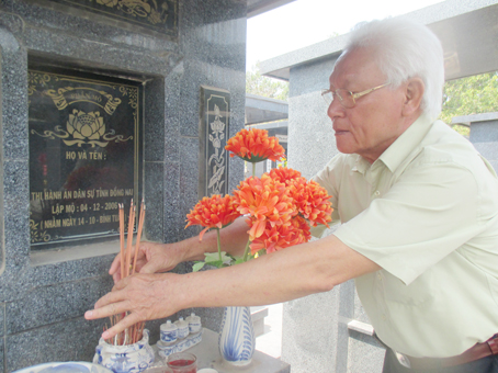Cựu chấp hành viên Đặng Đức Hậu bên một ngôi mộ do Cơ quan Thi hành án dân sự tỉnh lập năm 2006 trong vụ án “hài cốt giả”.