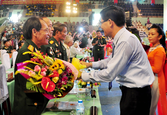Phó chủ tịch UBND tỉnh Trần Văn Vĩnh tặng hoa cho các anh hùng lực lượng vũ trang nhân dân đến dự lễ (ảnh: Đăng Tùng)