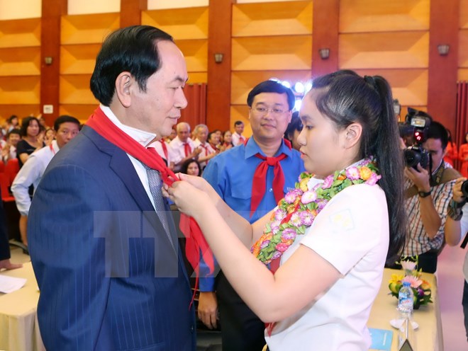 Thiếu niên Thủ đô Hà Nội đeo khăn quàng đỏ cho Chủ tịch nước Trần Đại Quang. (Ảnh: TTXVN)