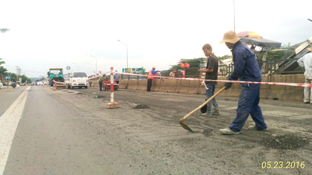 Đơn vị thi công đang tiến hành thảm nhựa tuyến quốc lộ 1 đoạn qua địa bàn huyện Thống Nhất chiều 23-5. Ảnh: H.Thắng