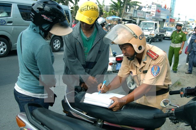 Cảnh sát giao thông xử lý người điều khiển phương tiện vi phạm giao thông. (Ảnh: Bùi Tường/TTXVN)