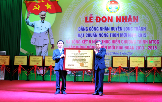Bí thư huyện ủy Nguyễn Quốc Cường và Chủ  tịch UBND huyện Ngô Thế Ân đang công bố Bằng công nhận  Huyện Long Thành đạt chuẩn Nông thôn mới