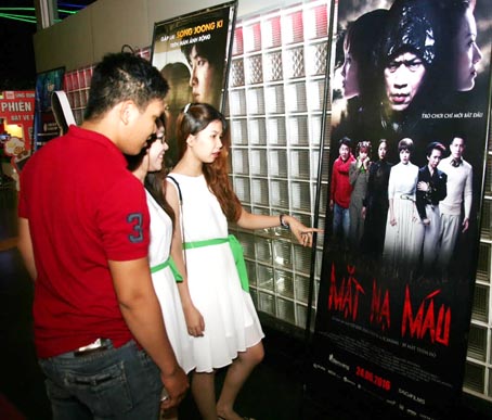  Một nhóm bạn trẻ tìm hiểu thông tin quảng cáo về phim Mặt nạ máu tại Cụm rạp CGV Biên Hòa trong ngày đầu bộ phim thuộc thể loại kinh dị Việt này khởi chiếu vào ngày 24-6.