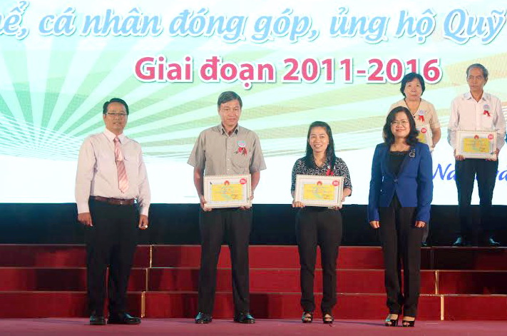 Phó chủ tịch UBND tỉnh Nguyễn Hòa Hiệp (bìa phải) và Giám đốc Sở Lao động - thương binh và xã hội Huỳnh Văn Tịnh (bìa trái) tặng bảng tri ân cho các tập thể và cá nhân