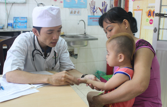 Bác sĩ Khoa Nhiễm Bệnh viện nhi đồng Đồng Nai khám cho một trẻ bị tay chân miệng. Ảnh: Đặng Ngọc. 