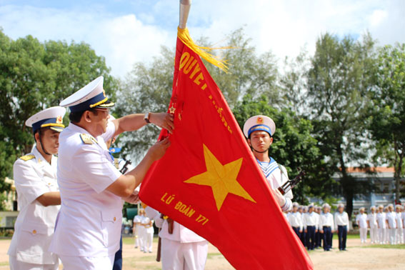 Thừa ủy quyền của Chủ tịch nước, Chuẩn đô đốc Phạm Hoài Nam, Tư lệnh Hải quân gắn huân chương bảo vệ Tổ quốc hạng Nhất lên lá cờ truyền thống Lữ đoàn 171