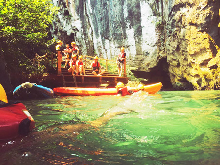 Du khách tắm bùn trong hang Tối (ảnh phải).