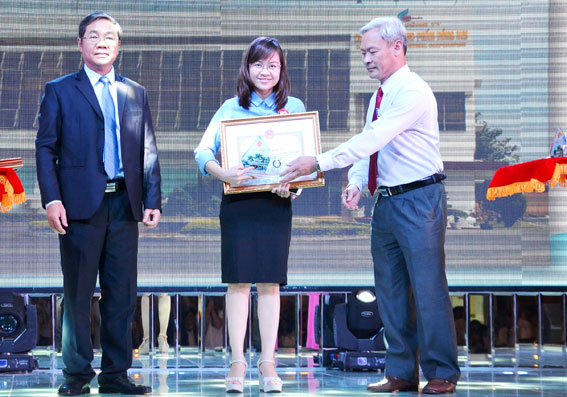 Bí thư Tỉnh ủy Nguyễn Phú Cường (phải) và Phó chủ tịch UBND tỉnh Nguyễn Quốc Hùng tặng bằng khen và biểu trưng cho doanh nghiệp nộp thuế tốt năm 2015 tại hội nghị 