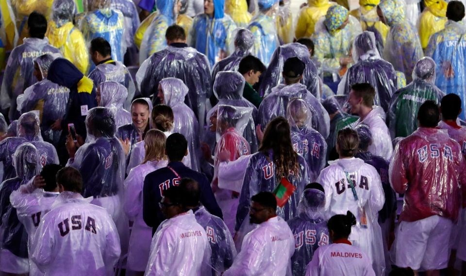 Đoàn vận động viên Mỹ mặc áo mưa tại lễ bế mạc. (Nguồn: AP)
