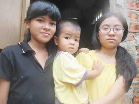 Trịnh Thị Linh (phải) thay mẹ chăm em, lo cơm nước cho cả nhà.