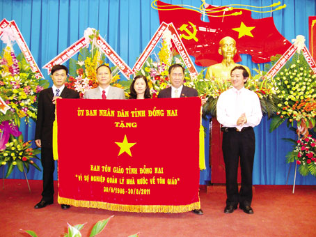 Lãnh đạo Ban Tôn giáo tỉnh Đồng Nai nhận Cờ thi đua của UBND tỉnh nhân kỷ niệm 25 năm thành lập Ban Tôn giáo tháng 8-2011. Ảnh: D.AN