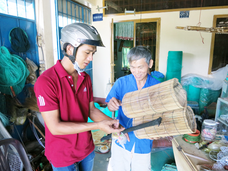 Ông Trần Văn Lâm đang bán dụng cụ bắt cá cho khách hàng.