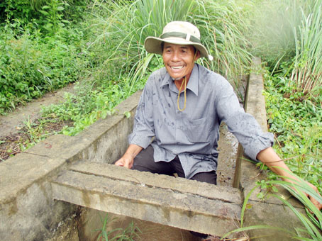 Nông dân Tám Quảng với nụ cười mãn nguyện về những đóng góp của mình ở cánh đồng Bến Thuyền.