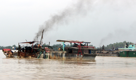 Trời chưa tắt nắng nhưng những chiếc ghe “bạch tuộc” đã bắt đầu cắm ống xuống sông bơm hút cát. (Ảnh chụp chiều 20-8 trên sông Đồng Nai, đoạn qua xã Long Tân, huyện Nhơn Trạch).