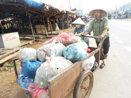 Vợ chồng ông Bùi Văn Hạ - bà Trần Thị Hằng cùng nhau dọn dẹp rác tại khu vực buôn bán phía trước Chợ 42.