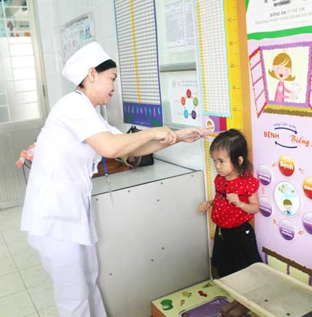 Nhân viên y tế Bệnh viện nhi đồng Đồng Nai đo chiều cao cho trẻ khi khám dinh dưỡng. Ảnh: N.Thư