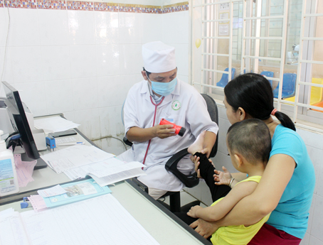 Bác sĩ Bệnh viện nhi đồng Đồng Nai khám bệnh cho một trẻ bị tay chân miệng. Ảnh: N.Thư.