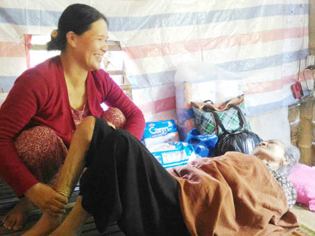 Chị Nguyễn Thị Kim Chuộng đang chăm sóc bà Nguyễn Thị Vui. Ảnh H.Nguyên