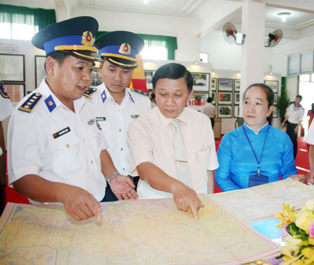 Đồng chí Đặng Mạnh Trung, Ủy viên Ban TVTU, Trưởng Ban Tuyên giáo Tỉnh ủy (thứ hai từ phải qua) cùng sĩ quan hải quân xem bản đồ được trưng bày tại triển lãm bản đồ và trưng bày tư liệu “Hoàng Sa, Trường Sa của Việt Nam - những bằng chứng lịch sử và pháp lý” tại Bảo tàng Đồng Nai do Bộ Thông tin - truyền thông phối hợp với UBND tỉnh tổ chức. Ảnh: V.TRUYÊN