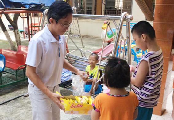 Ông Bùi Phước Thắng, Chủ nhiệm CLB tennis Hồng Phúc tặng quà cho các em tại Trung tâm Nuôi dưỡng trẻ em mồ côi khuyết tật TP. Biên Hòa